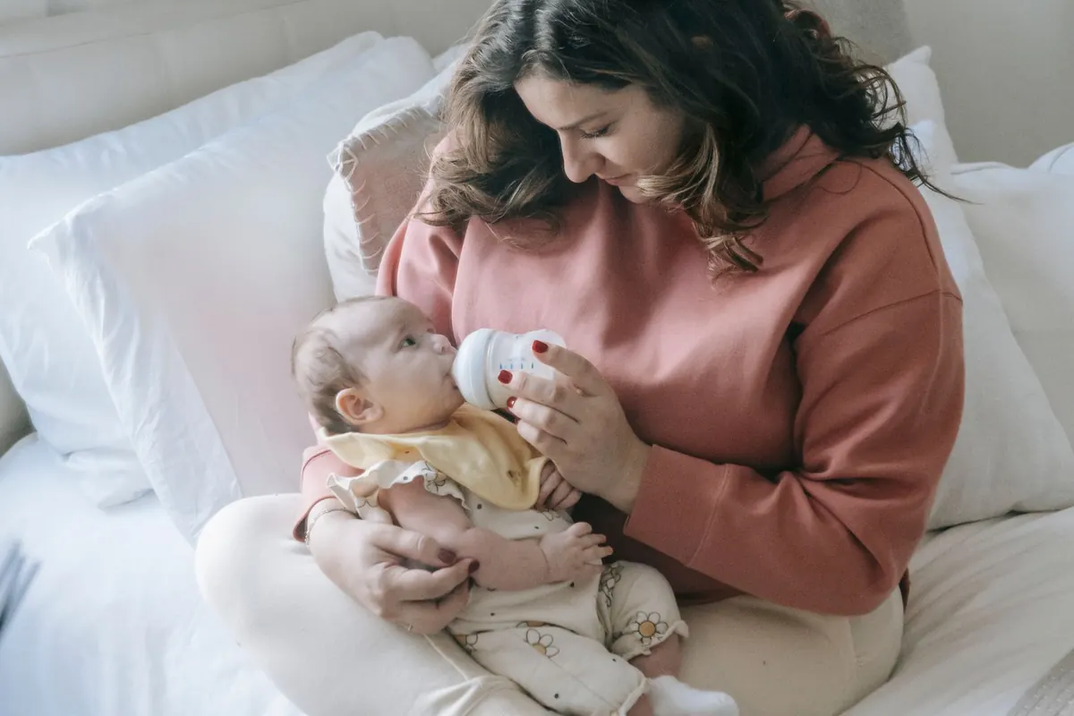 Una madre sostiene a su bebé mientras le da el biberón