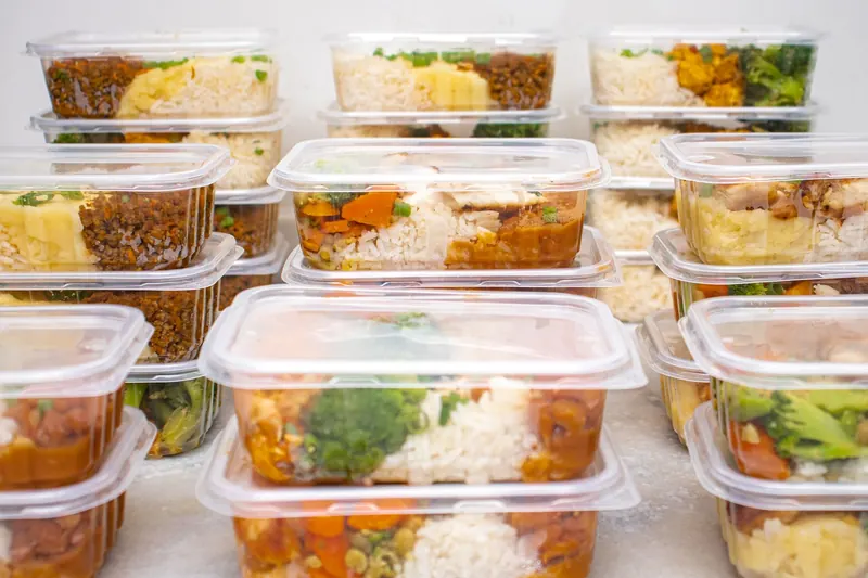 Raciones de arroz, verduras y otros alimentos en recipientes individuales