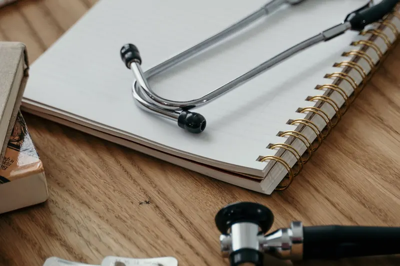 Estetoscopio y cuaderno sobre una mesa de consulta