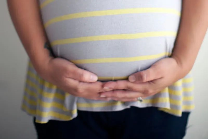 Manos sobre el vientre de una mujer embarazada