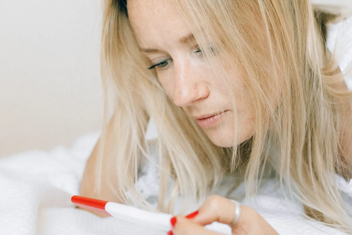 Mujer observando una prueba de embarazo