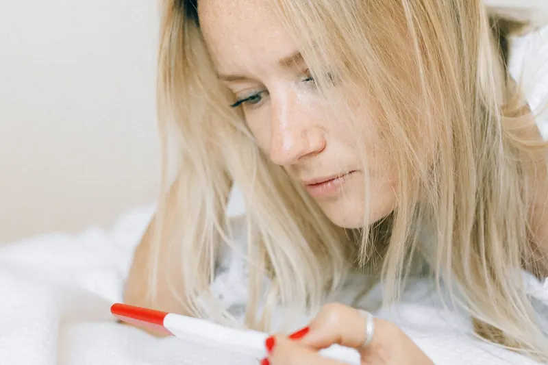 Mujer observando una prueba de embarazo